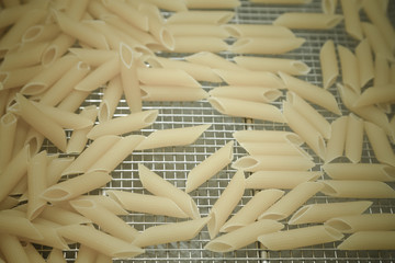 Many pasta pieces on a metal background. Selective focus. Shallow depth of field. Toned