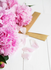 invitation card, craft envelope and pink peony flowers