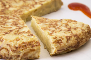 spanish potato omelette dish and tomato sauce