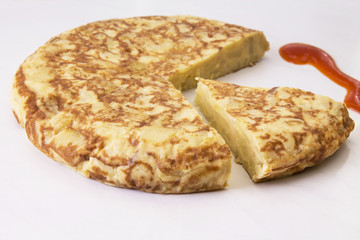 spanish potato omelette dish and tomato sauce