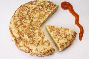spanish potato omelette dish and tomato sauce