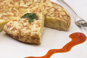 traditional spanish omelette dish with tomato sauce
