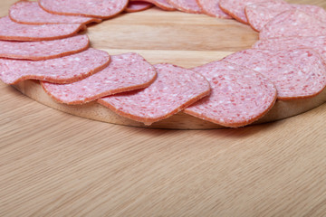 Sausage on a light wooden table. Shallow depth of field. Selective focus