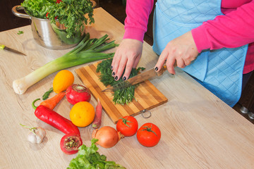 woman hands cutting vegetables on kitchen blackboard. Woman preparing vegetables
