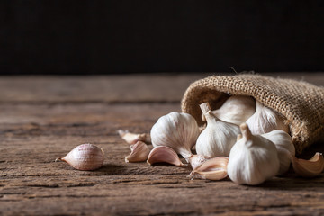 Garlic cloves and bulb on wooden background