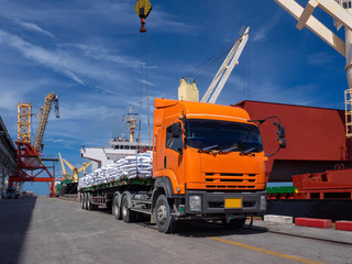 Sugar bags are loading in hold of bulk-vessel at industrial port,Pick up sugar bags from truck to ...