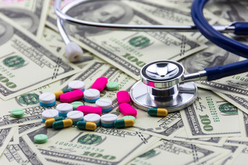 Stethoscope with medicines on dollar banknotes, healthcare payment concept