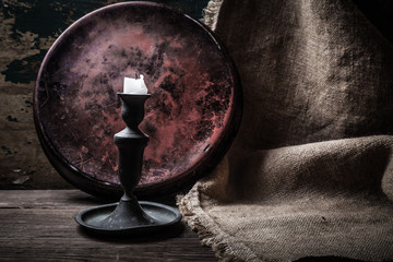 Old candle on a wooden background. Toned