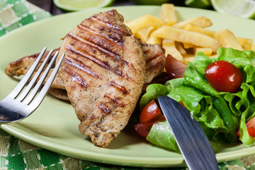 Grilled chicken breasts served with fries