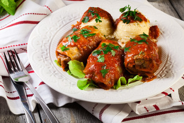Stuffed cabbage with meat and rice served with boiled potatoes and tomato sauce