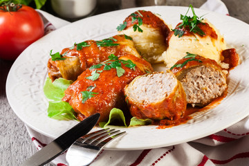 Stuffed cabbage with meat and rice served with boiled potatoes and tomato sauce