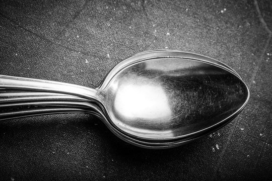 Lot of metal cutlery on a black background. Selective focus. Shallow depth of field. Toned