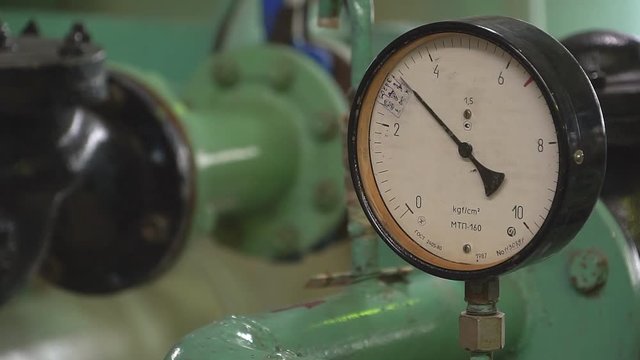 Closeup of pressure gauge,pressure gauge measuring gas pressure. Pipes and valves at oil and gas industrial plant.