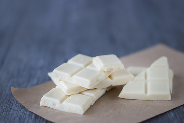 White chocolate pieces on gray background.