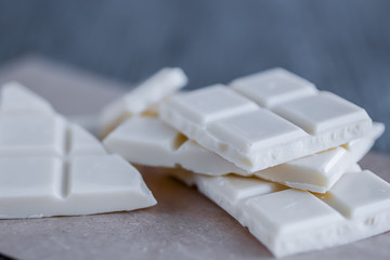 White chocolate pieces on gray background.