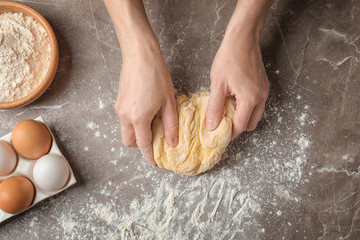 Woman kneading dough for pasta at table, top view