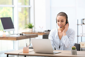 Female receptionist with headset at desk in office