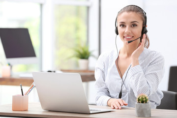 Female receptionist with headset at desk in office