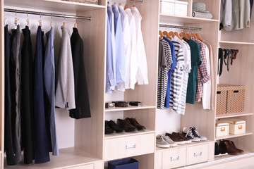 Large wardrobe with different clothes and shoes