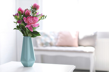 Vase with beautiful peony flowers on table indoors