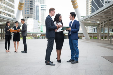 Group of business people standing in the city and discussing ideas for business future. multi culture of business people, African, Caucasian and Asian.