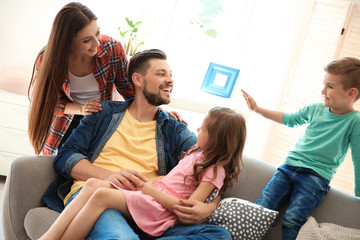 Young couple spending time with children at home. Happy family