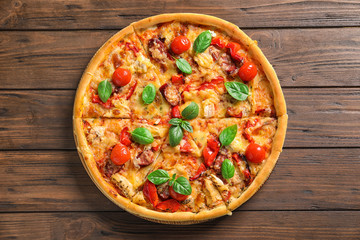 Delicious pizza with tomatoes and sausages on wooden table, top view