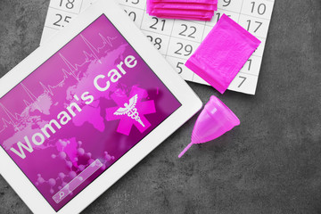 Flat lay composition with tablet, calendar and feminine hygiene items on grey background....
