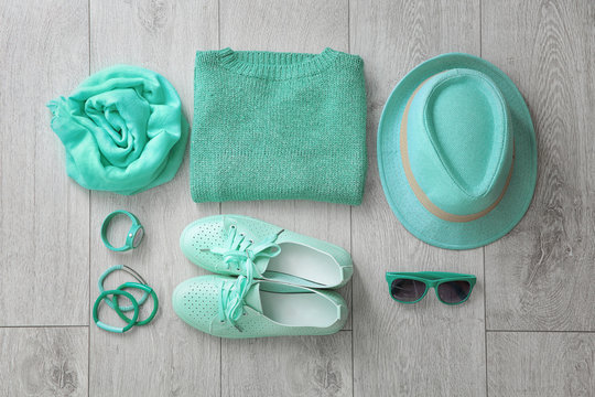 Flat lay composition with set of mint clothes and accessories on wooden background