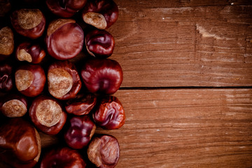 Lot of chestnuts on the old wooden background. Toned