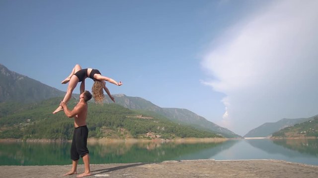 Against the background of nature gymnasts perform tricks