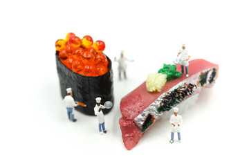 Miniature people : Chef with Salmon egg on sushi nigiri roll on white background.