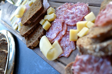 The sliced sausages and cheese on a kitchen table.