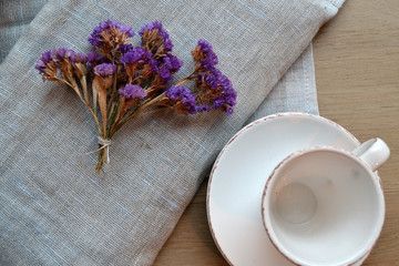 Empty coffee cup and kitchen textile on a table.