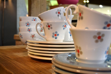 Ceramic coffee cups on a wooden shelf.