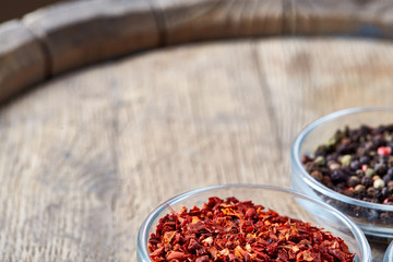 Bowls with different types of spicy on wooden barrel, top view, close-up, selective focus.