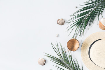 Summer composition. Tropical palm leaves, hat, coconut on pastel blue background. Summer concept....