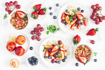 Fruit salad with strawberry, blueberry, peach, banana, grape and fresh fruits on white background. Flat lay, top view