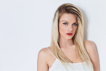 Naklejka premium Blonde woman portrait wearing eyeliner and red lipstick and looking at camera