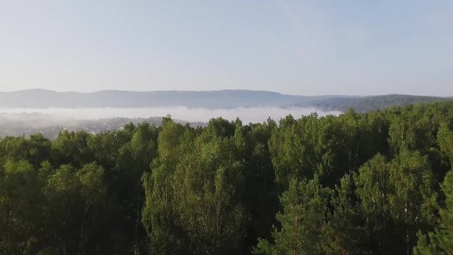 Empty railway along the river in the Ural Mountains at summer fog morning - Aerial Photography, top view