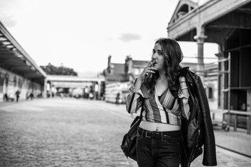 Fototapeta premium Woman in the street with windbreaker on the shoulder