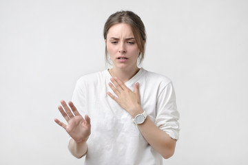 European woman in white t-shirt having a sore throat. Lost a voice. Problem with health.