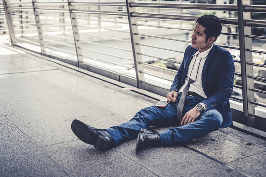 businessman unemployed from company sitting on street, he is feeling of stressed and sadness, concept of business failure and unemployment problem. vintage style