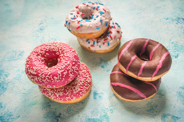 Colorful donuts on blue stone table. Top view