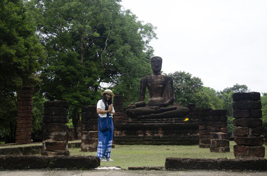 Travelers thai woman walking visit and travel take photo in ancient building and ruins of Kamphaeng Phet Historical Park