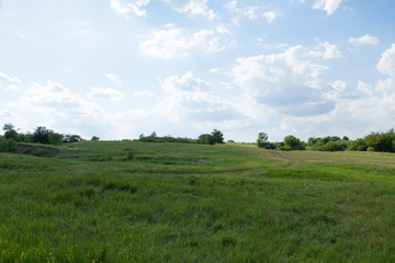 dirt road rural on a hill in the grass horizon and cloudy blue tones