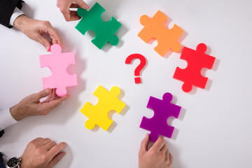 Group Of Businesspeople Holding Jigsaw Puzzle