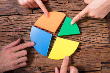 Businesspeople Connecting Pieces Of Pie Chart