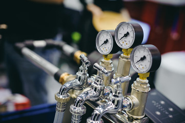 Thermometer, pipes and faucet valves of heating system in a boiler room.