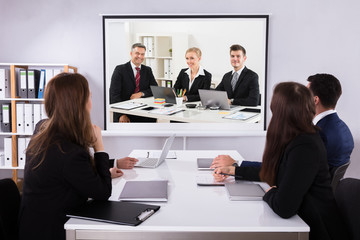 Group Of Businesspeople Looking At Projector